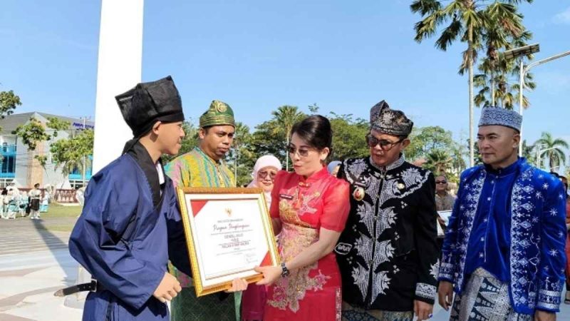 Wali Kota Singkawang, Tjhai Chui Mie menyerahkan penghargaan pada Upacara Hardiknas 2025. - Foto Pemkot Singkawang
